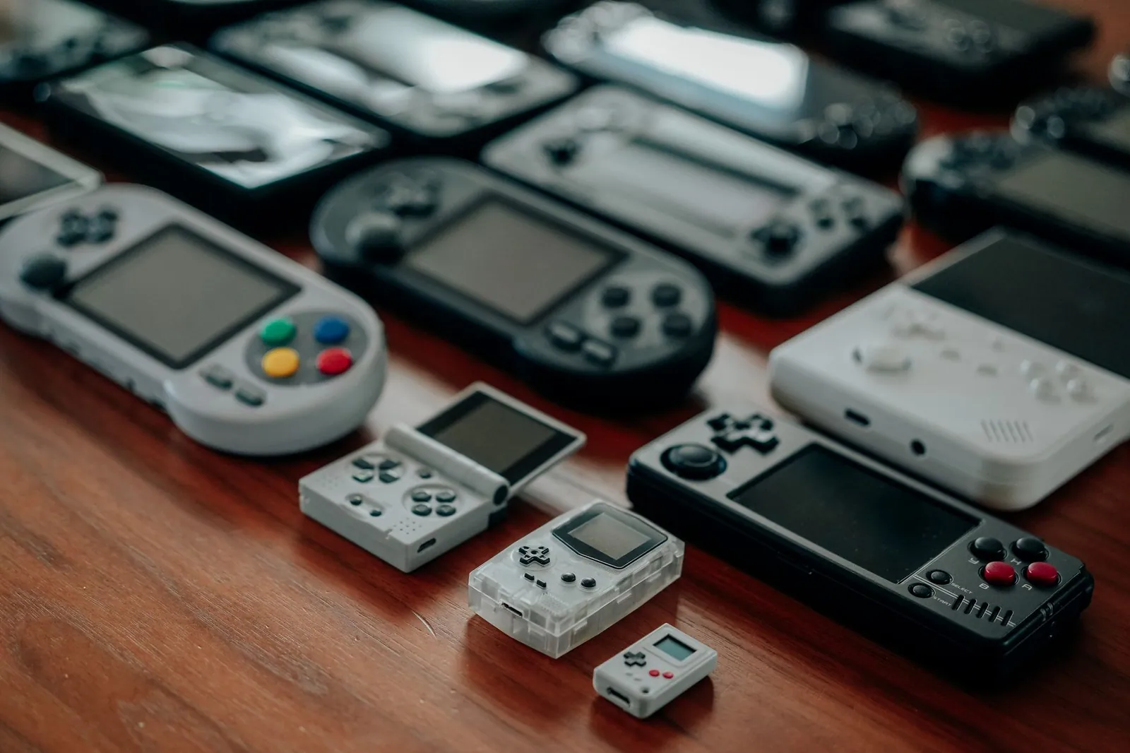 Collection de consoles portables rétro posées sur une table en bois