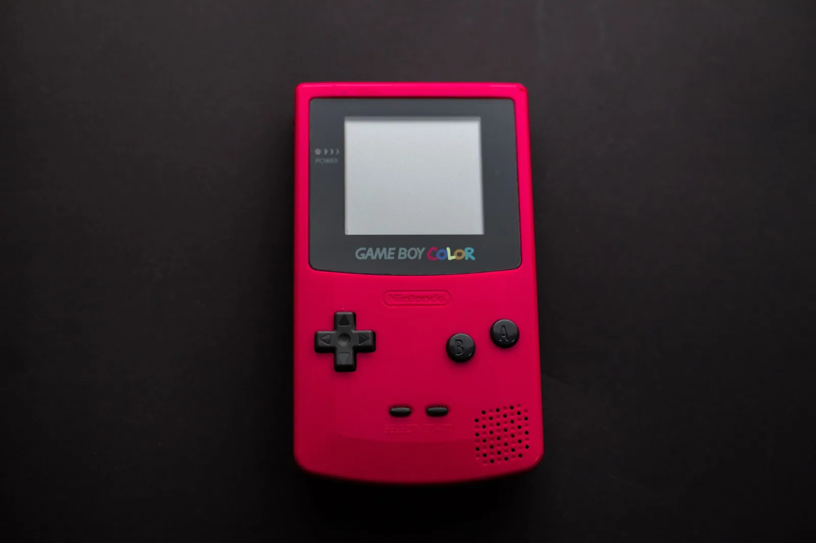 Game Boy Color rouge photographiée sur fond sombre