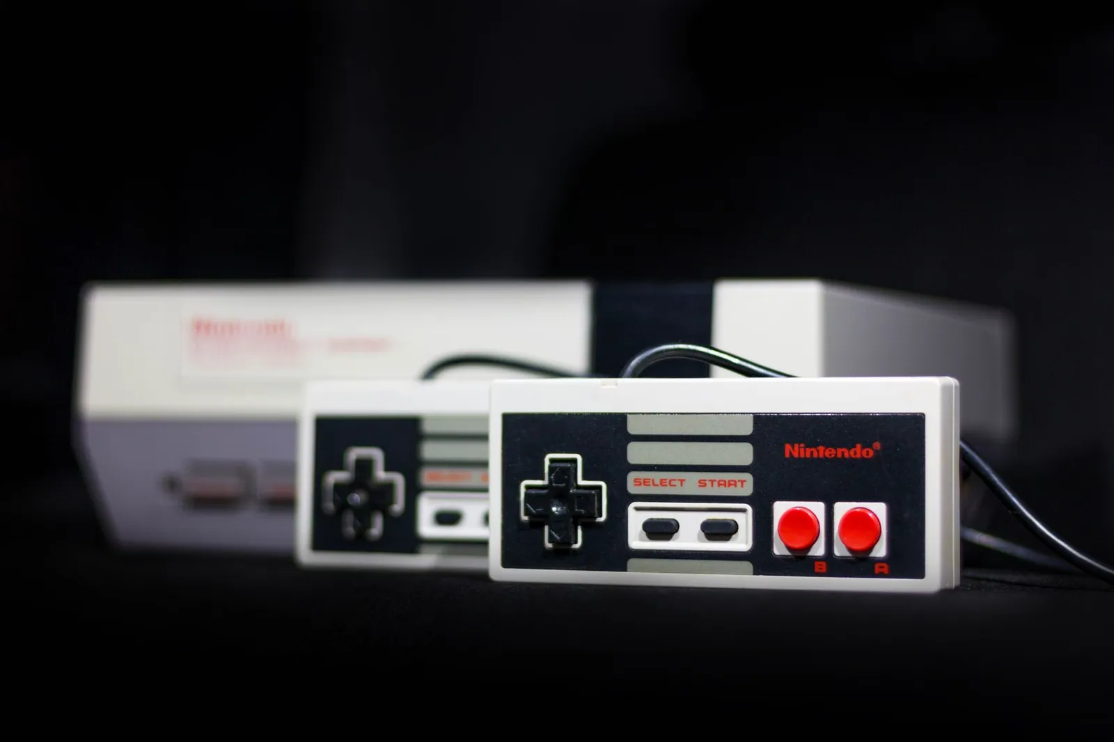Console NES et ses manettes grises photographiées de près